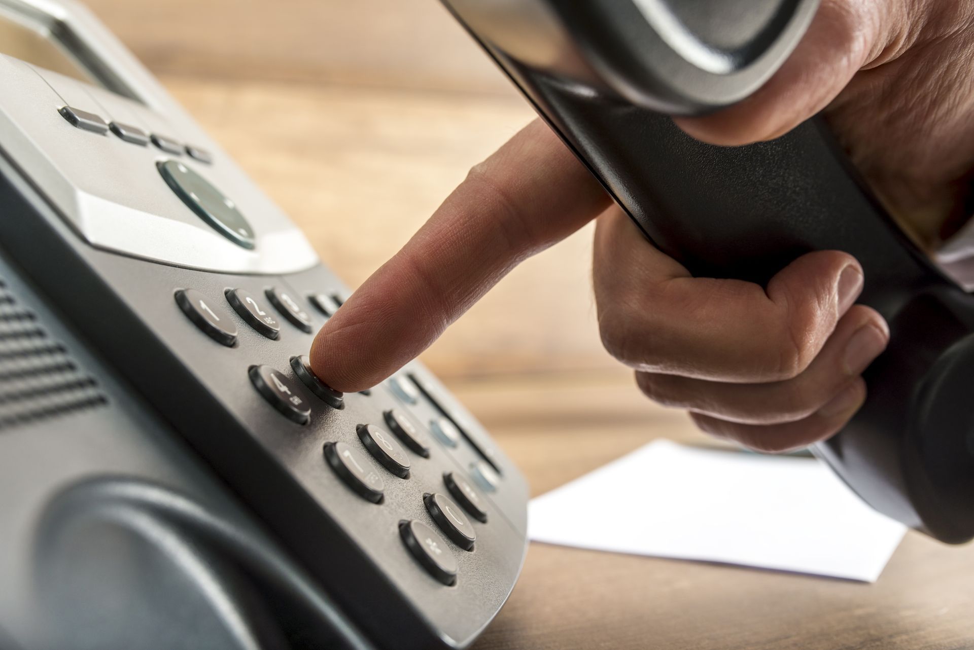A person is pressing a button on a telephone
