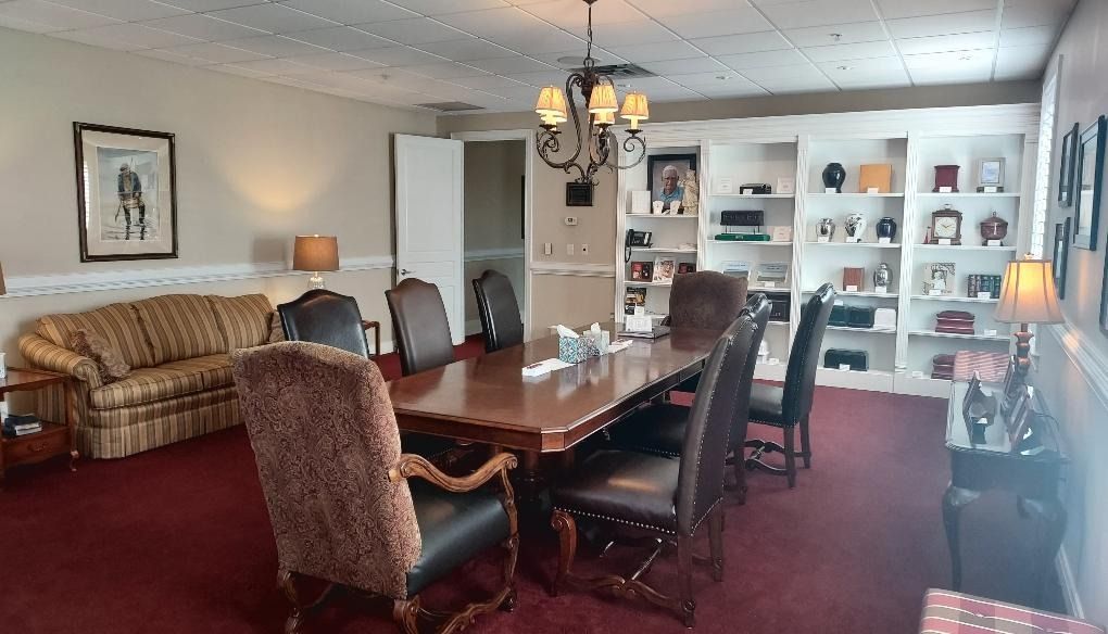 Elegant dining room with long wooden table, upholstered chairs, chandelier, and built-in display shelves