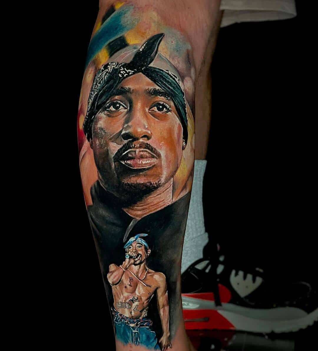 A hyper-realistic tattoo of Tupac Shakur featuring a large portrait above a smaller figure of him performing on a stage.