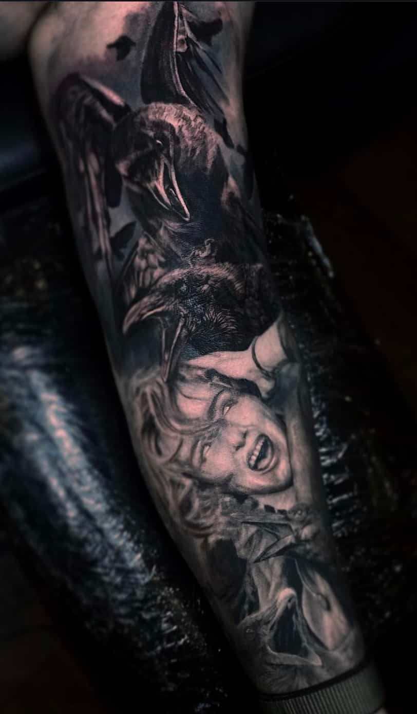 A dark, realistic tattoo on a forearm depicting a screaming figure being reached for by a clawed, shadowy creature.
