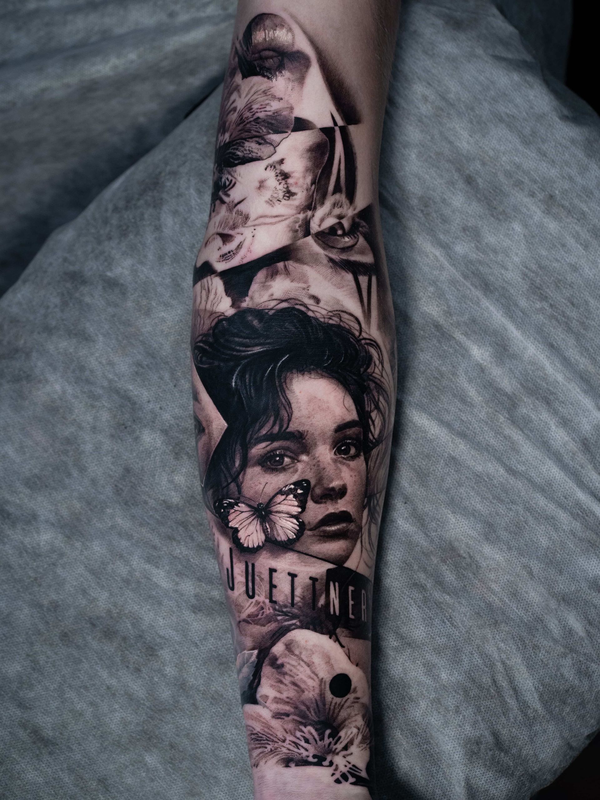 A forearm tattoo featuring a portrait of a person with a butterfly on their cheek and blurred imagery above and below.