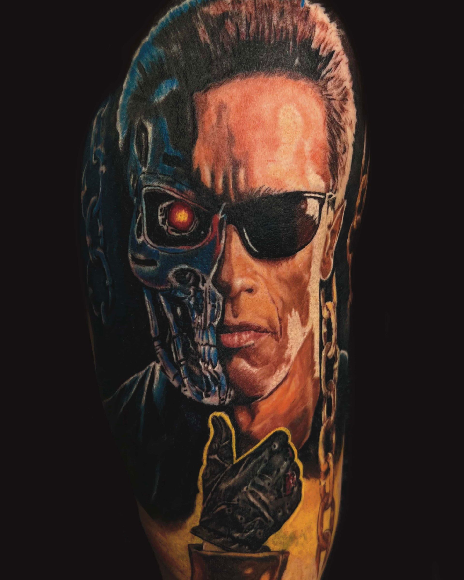 A tattoo of the Terminator with half a metallic skull, a glowing red eye, and a hand giving a thumbs-up in molten metal.