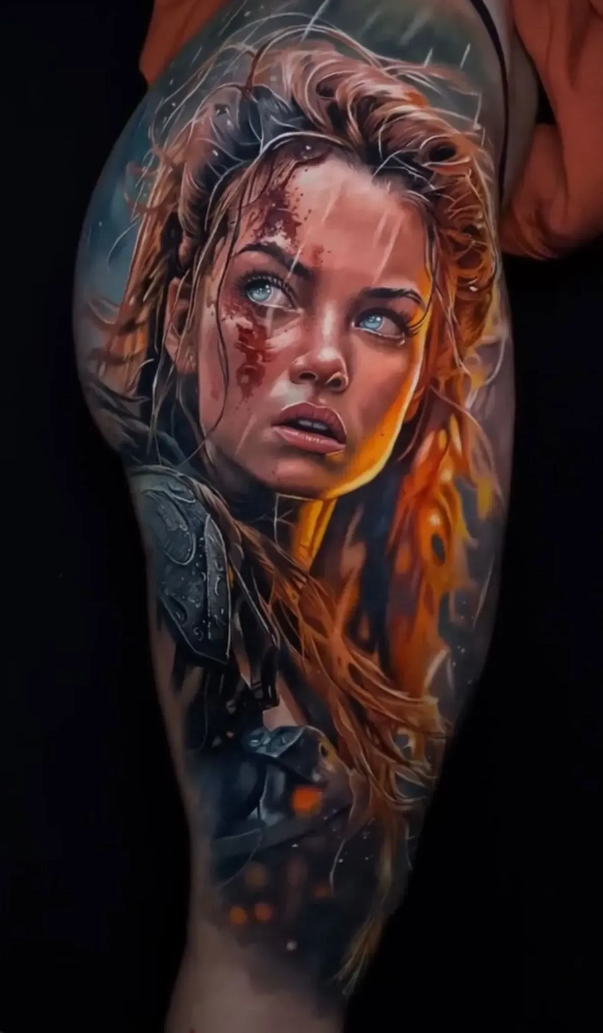 A realistic tattoo of a character with ginger hair, weathered skin, and an intense gaze, rendered in warm, fiery tones.
