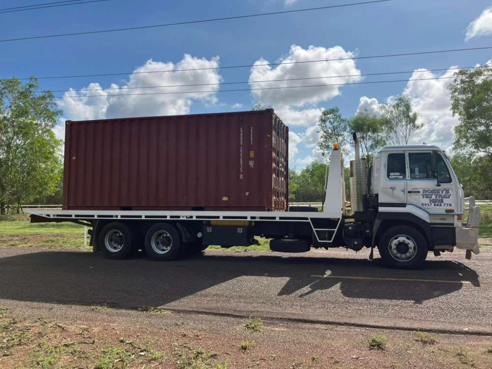 A Tow Truck With A Container On The Back Is Parked On The Side Of The Road — Fewmore Contracting in Palmerston, NT