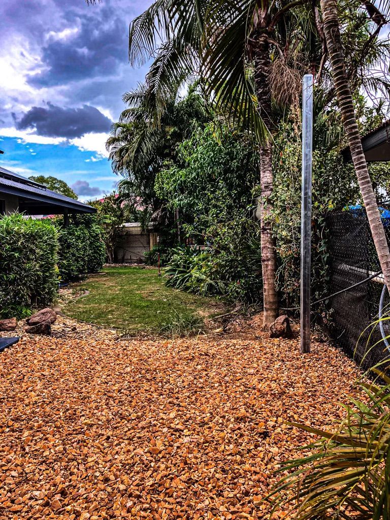 A Pile of Wood Chips is Sitting in the Middle of a Backyard — Fewmore Contracting in Yarrawonga, NT