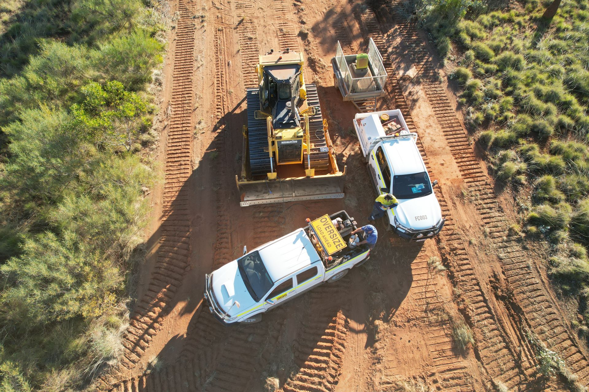 An Aerial View of a Bulldozer and a Truck on a Dirt Road — Fewmore Contracting in Katherine, NT
