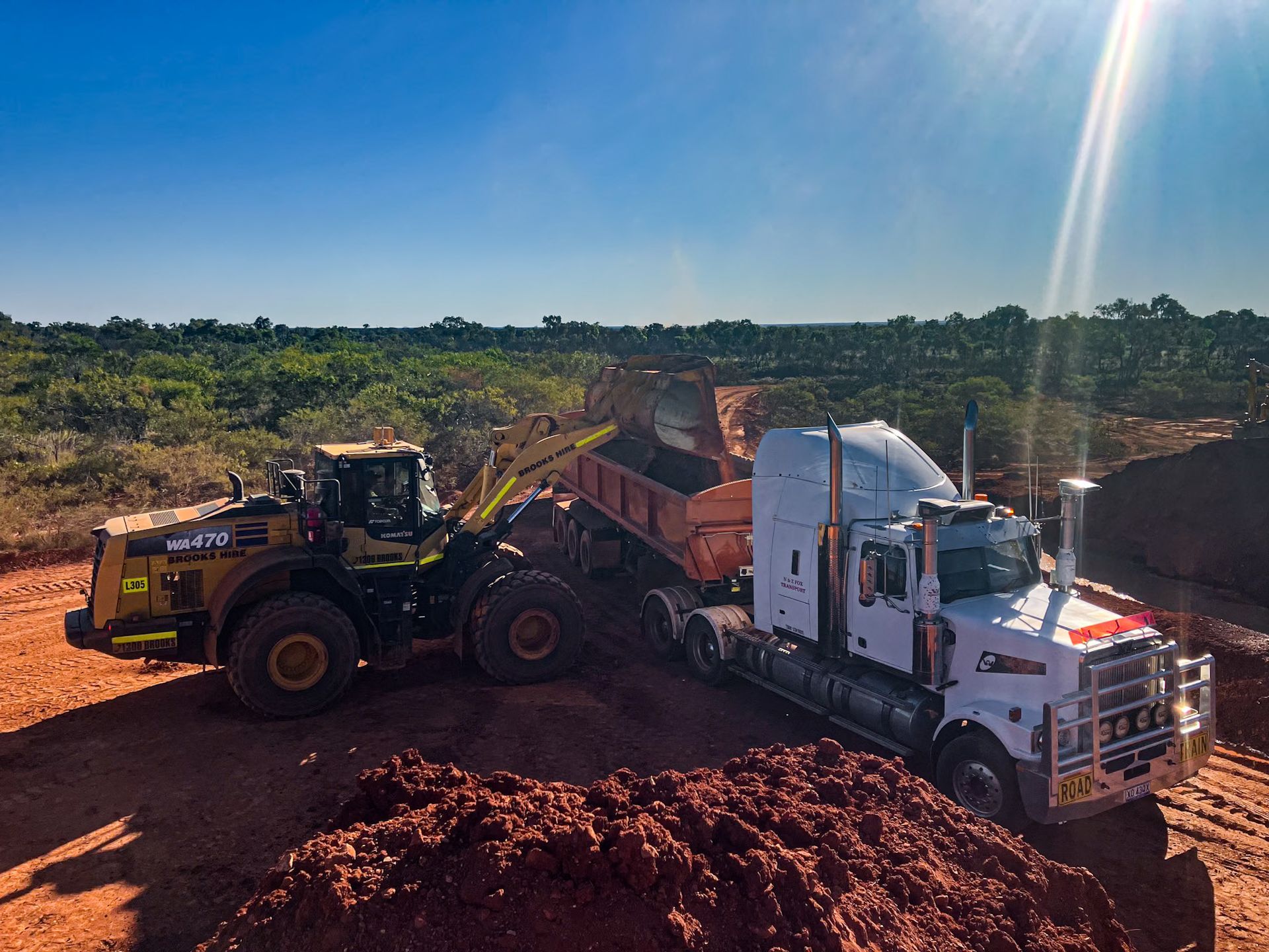 A Dump Truck is Being Loaded With Dirt by a Bulldozer — Fewmore Contracting in Katherine, NT