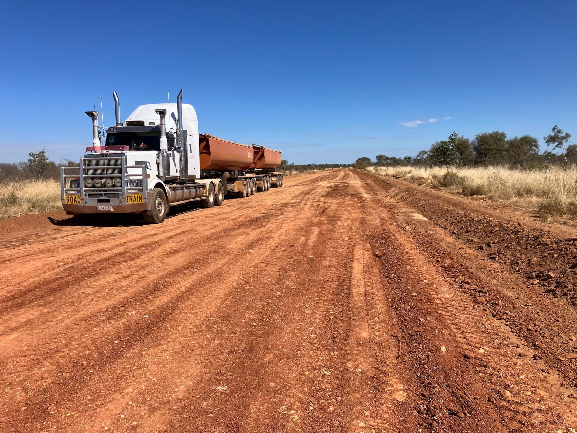 A Semi Truck is Driving Down a Dirt Road — Fewmore Contracting in Katherine, NT