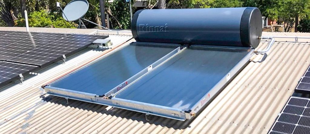 A Solar Water Heater is Sitting on Top of a Roof Next to Solar Panels — Fewmore Contracting in Palmerston, NT