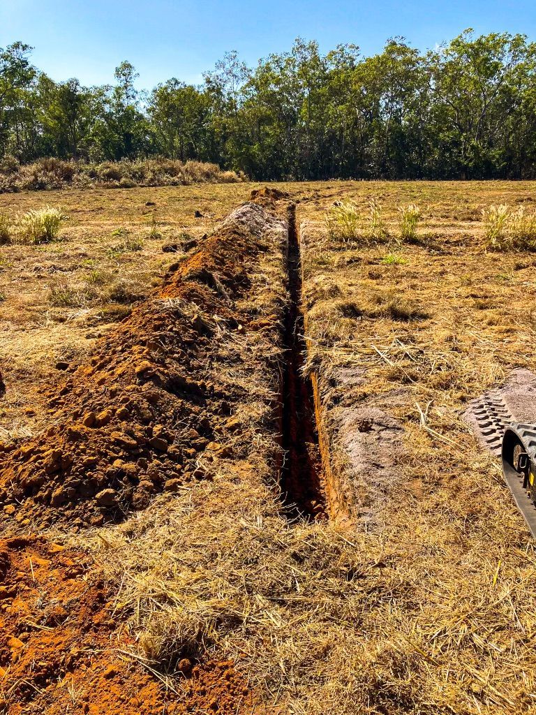 A Person is Digging a Trench in the Dirt in a Field — Fewmore Contracting in Yarrawonga, NT
