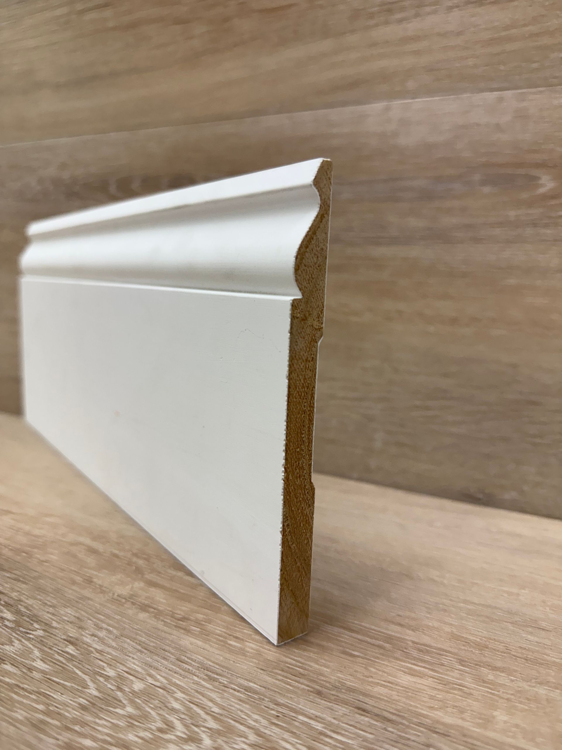 A white skirting baseboard is sitting on top of a wooden table.