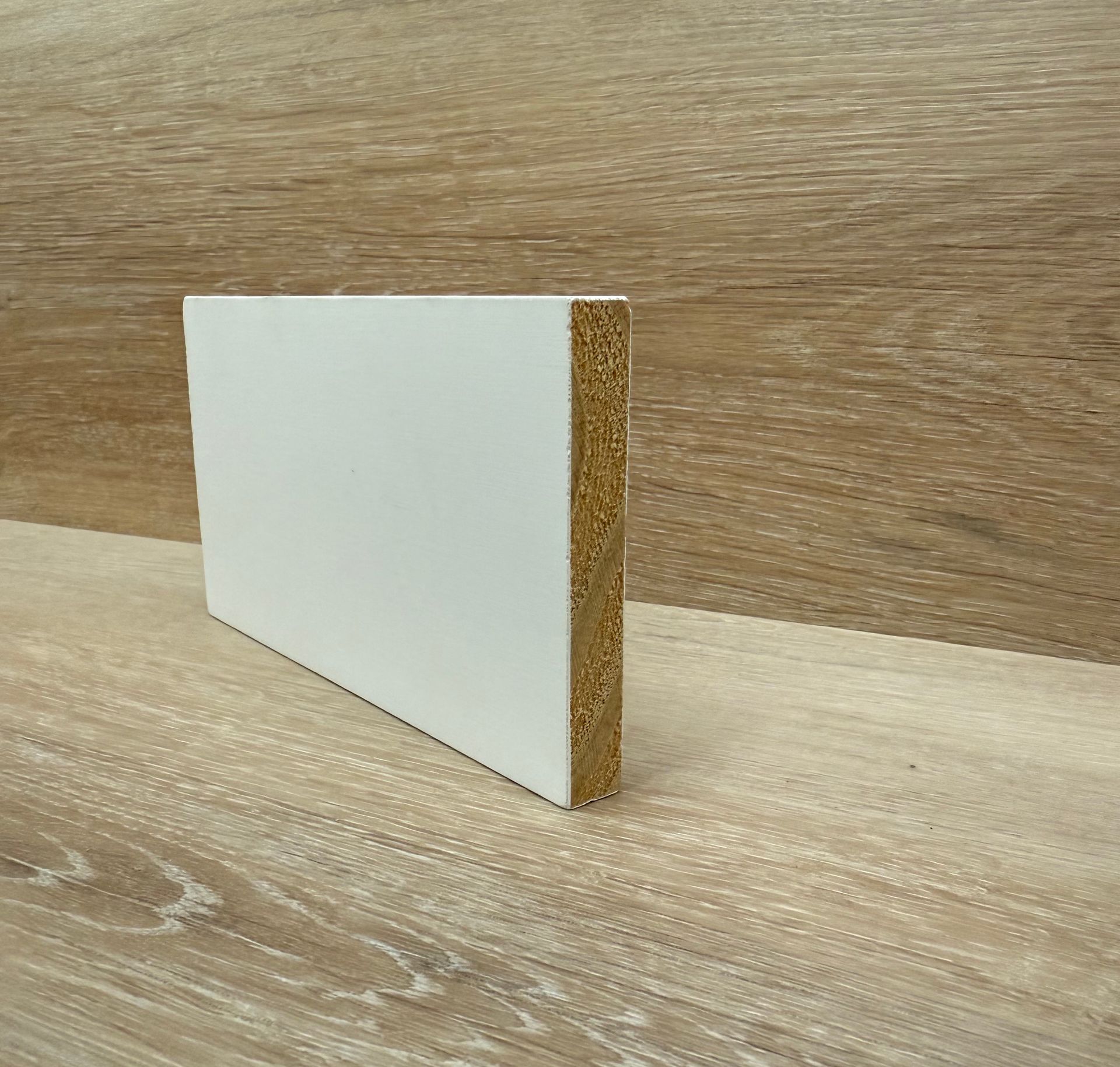 A piece of white plywood is sitting on a wooden table.