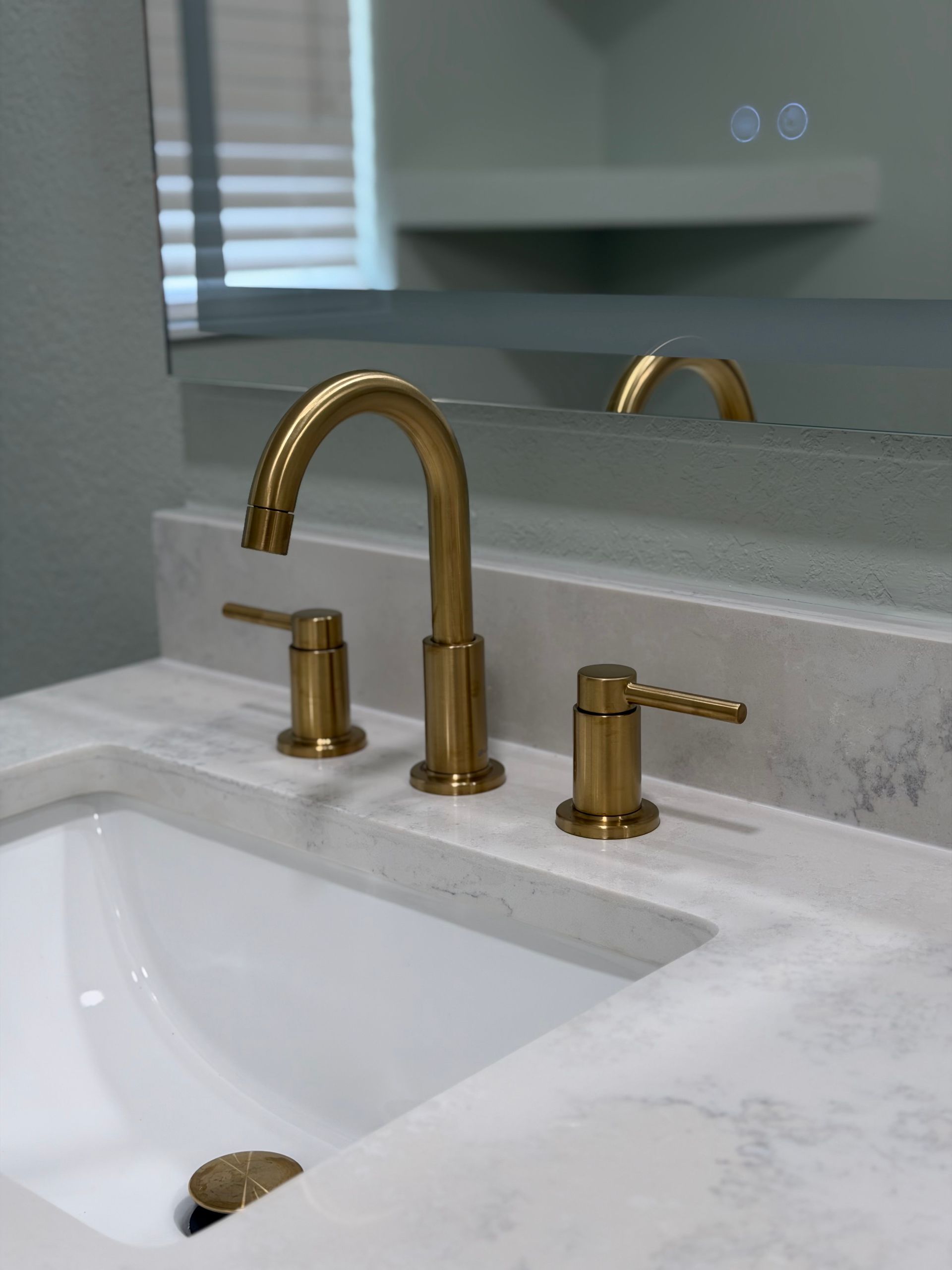 Brushed Gold tap and sink, backlit mirror and quartz countertop