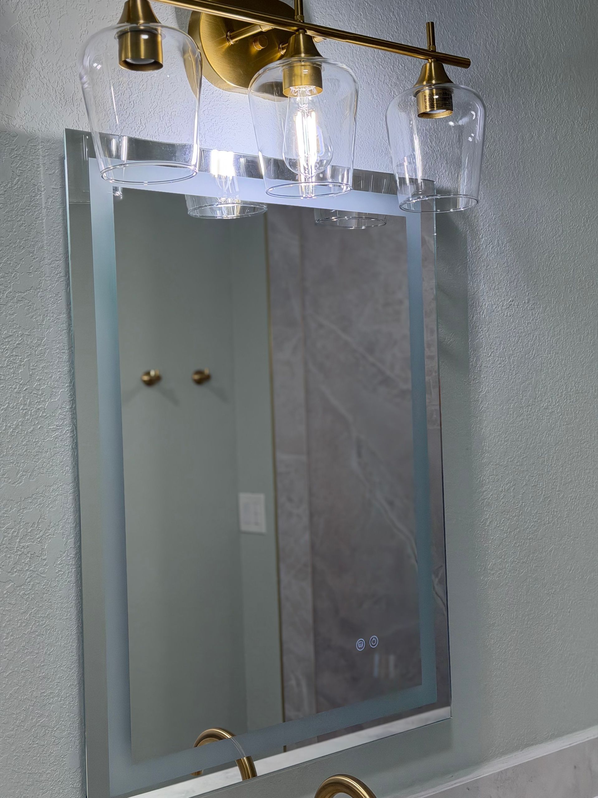 backlit mirror and brushed gold lamp 