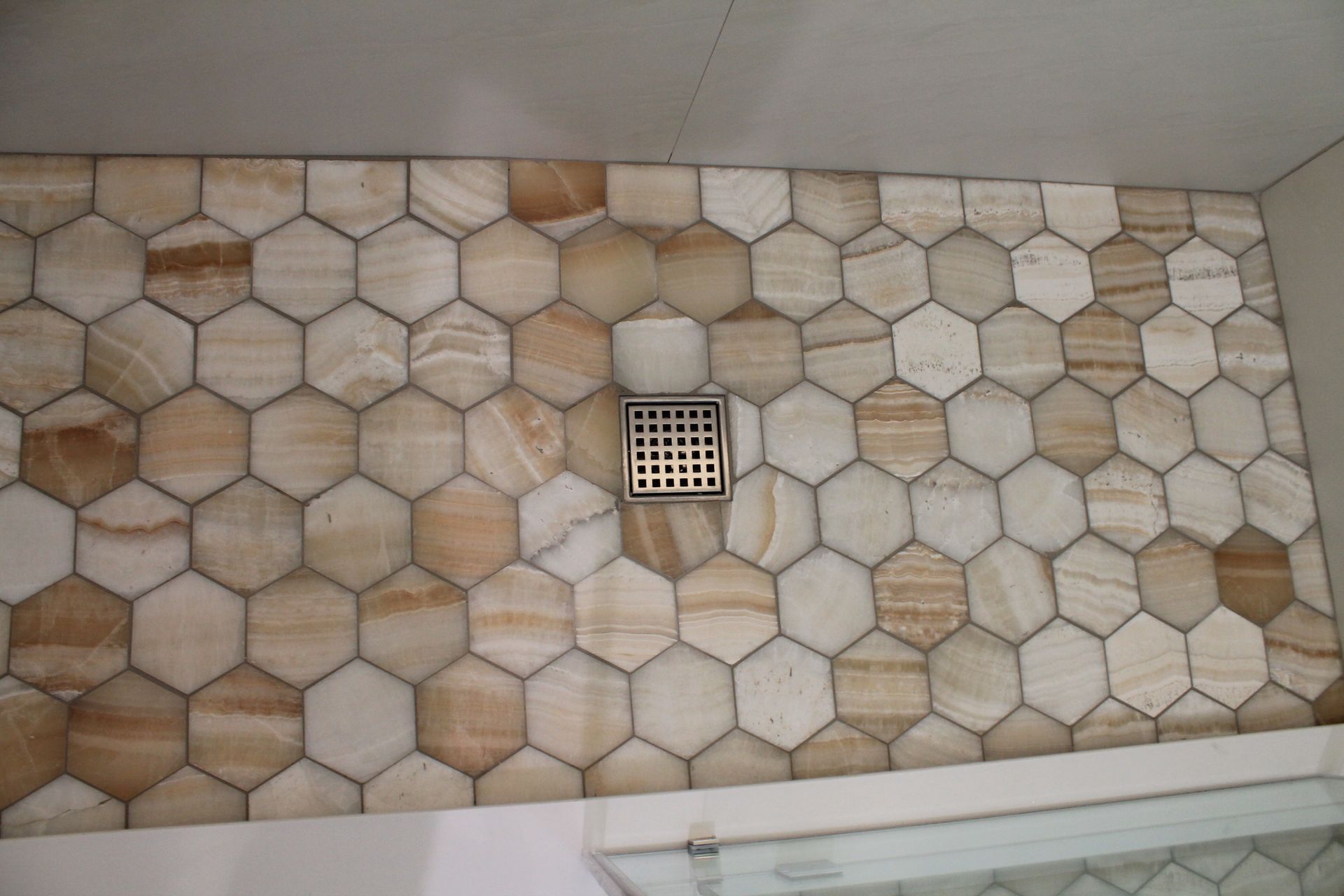 Updated bathroom shower with hexagon beige-orange tile floor
