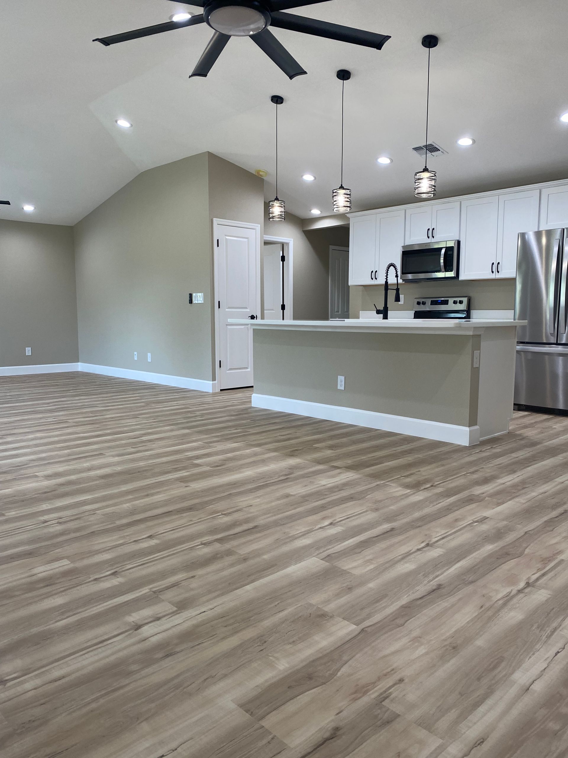 A kitchen with stainless steel appliances and a ceiling fan