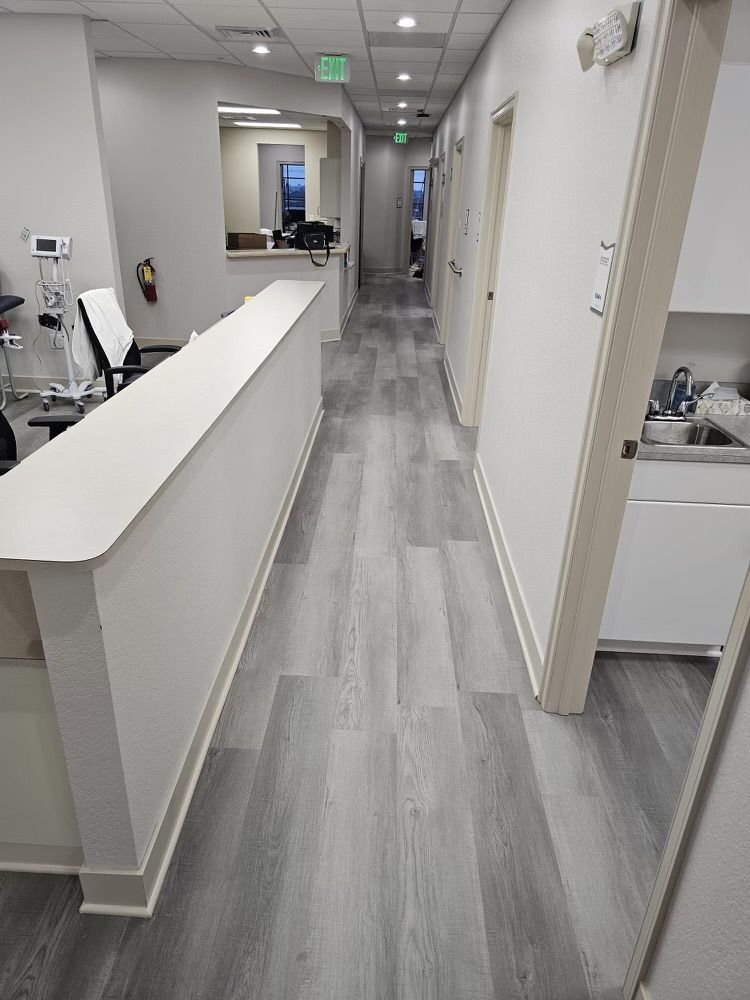 A long hallway with a white counter in the middle of it.