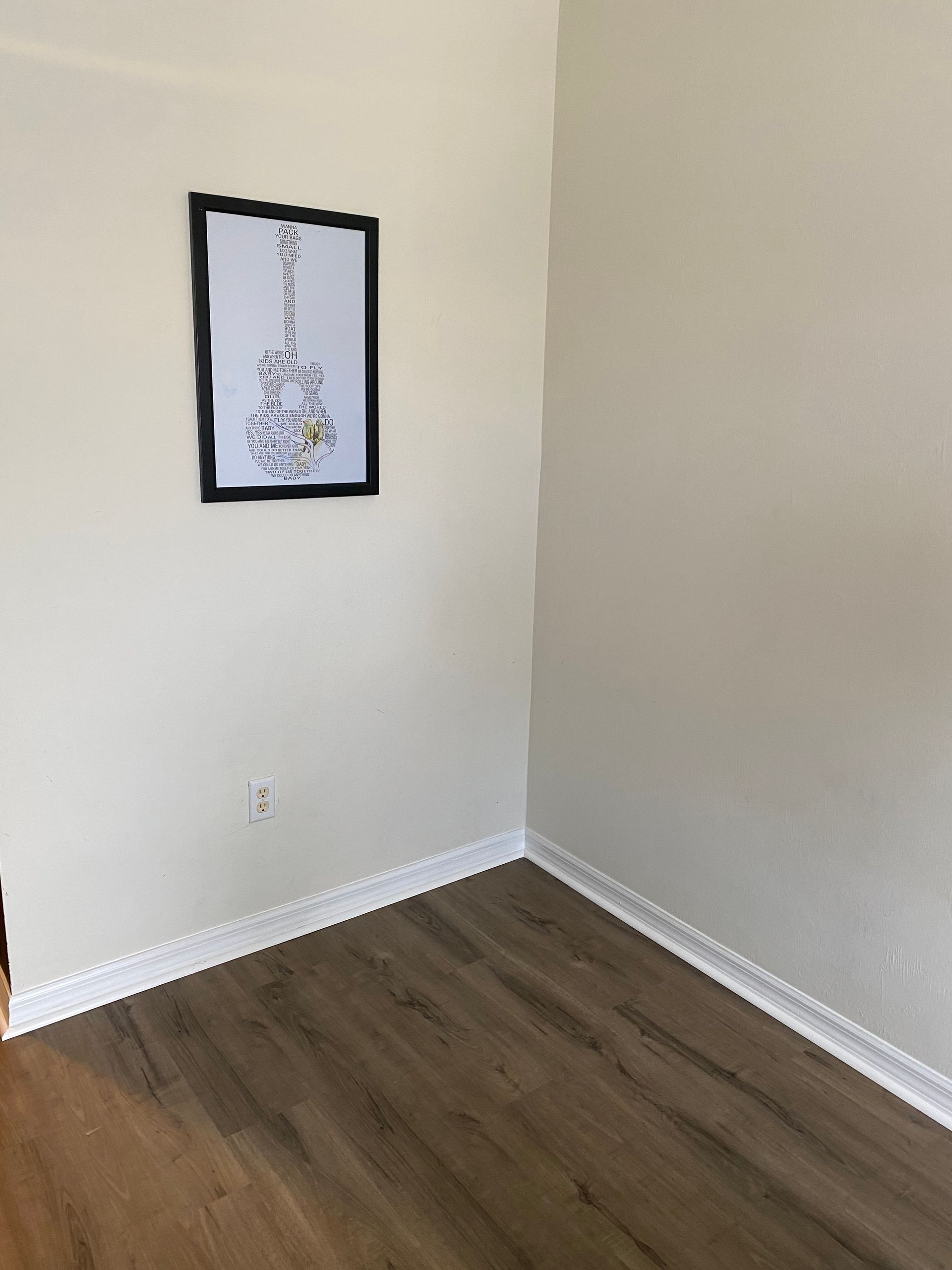 A room with hardwood floors and a picture on the wall.