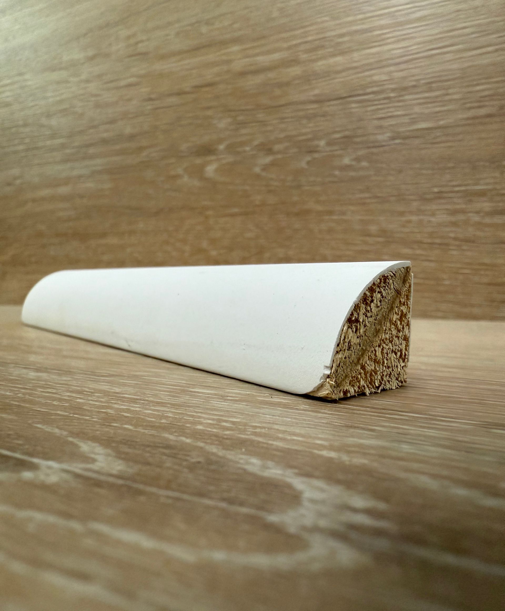 A white piece of wood is sitting on top of a wooden table.