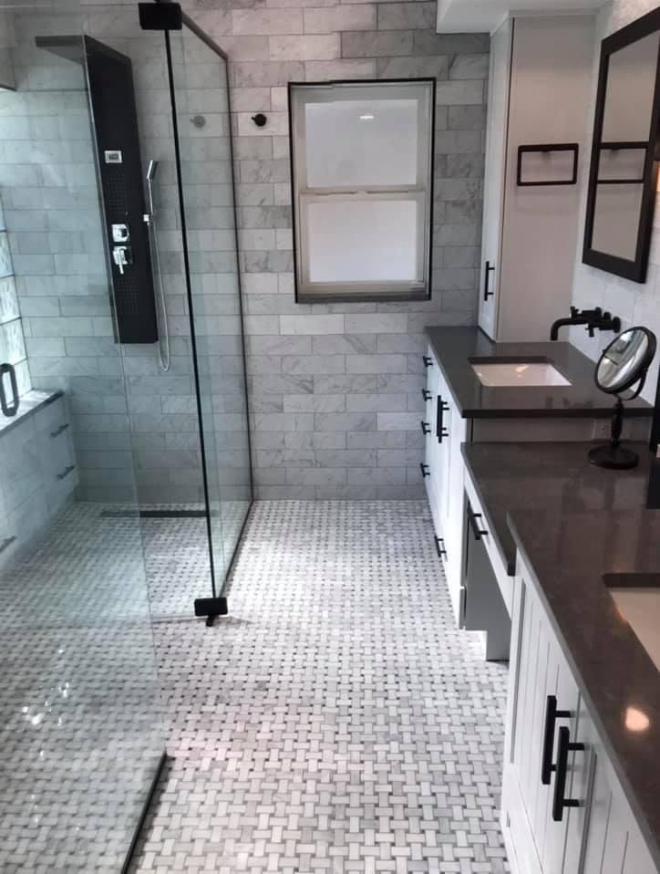 A bathroom with a walk in shower and a sink