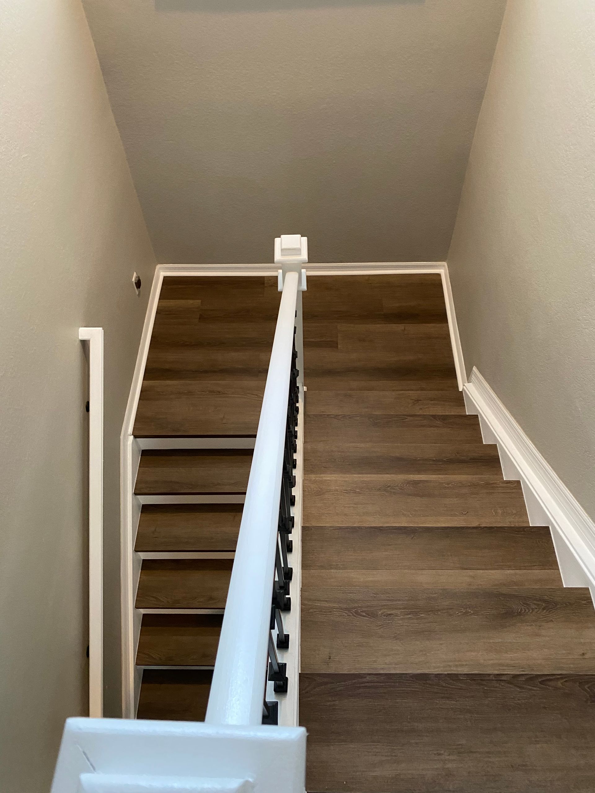 A staircase with wooden steps and a white railing