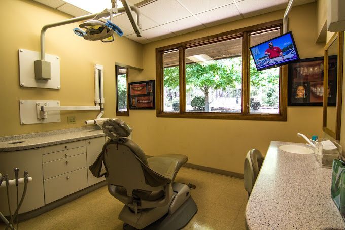 A dental office with a dental chair and a sink.