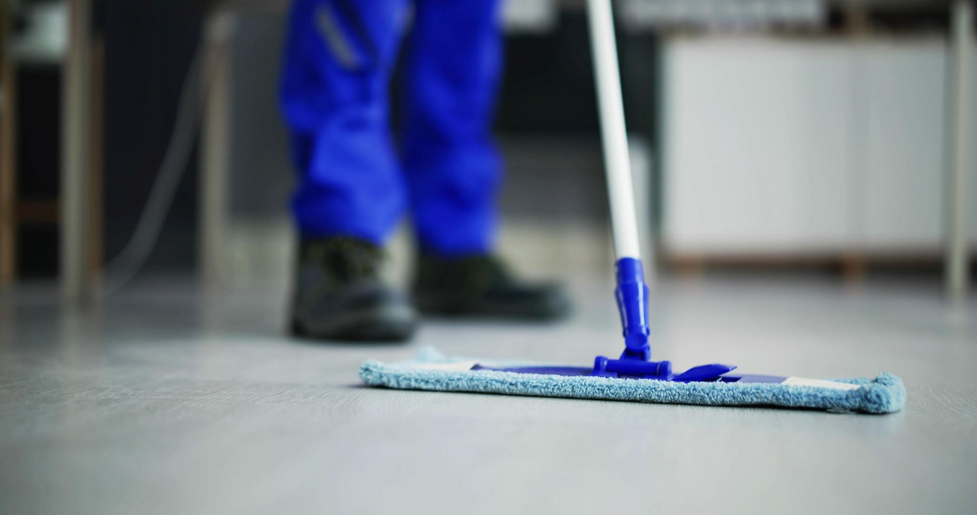 A person is cleaning the floor with a mop.