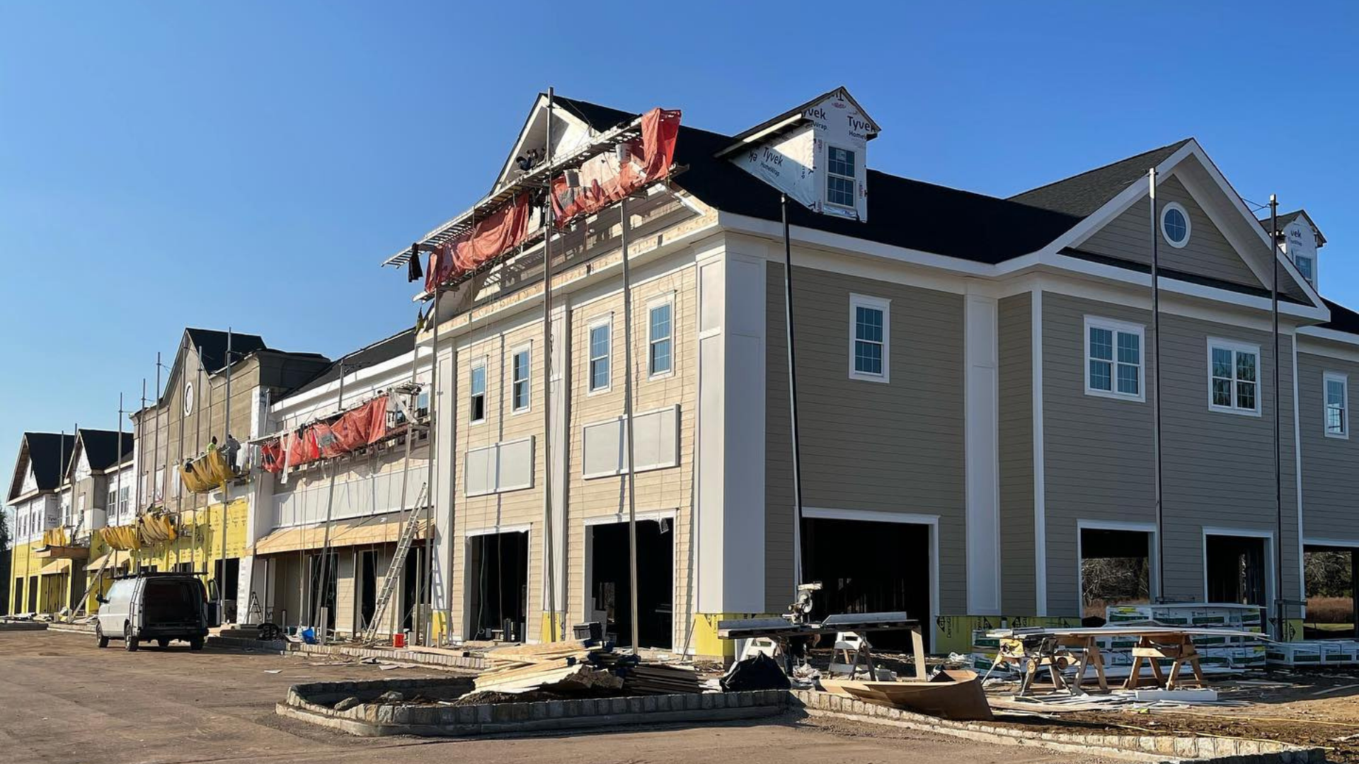 Partially damaged apartment building with exposed framing and debris at a construction site