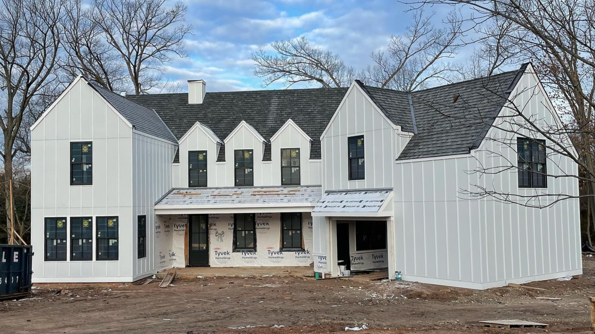 Partially built white two-story house with dark roof and unfinished front yard (a project of Paese Construction LLC)