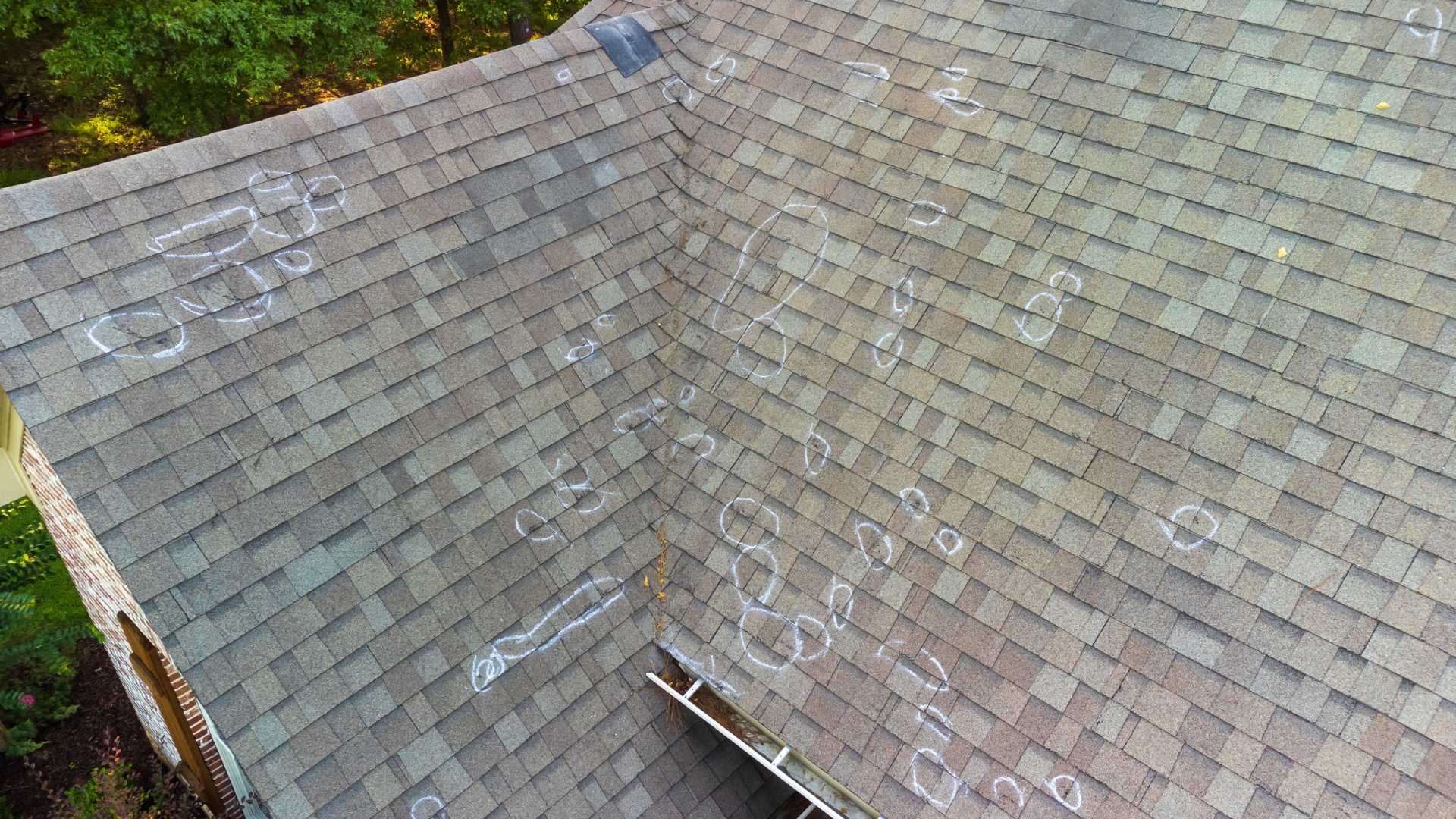 Slate roof with weathered gray shingles and a ridge line viewed from above