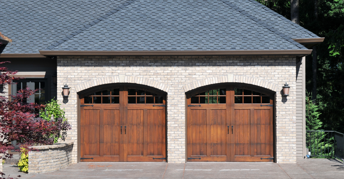 A house with two wooden garage doors and a blue roof