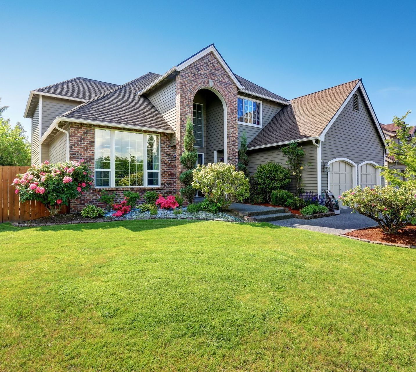 A large house with a lush green lawn in front of it.