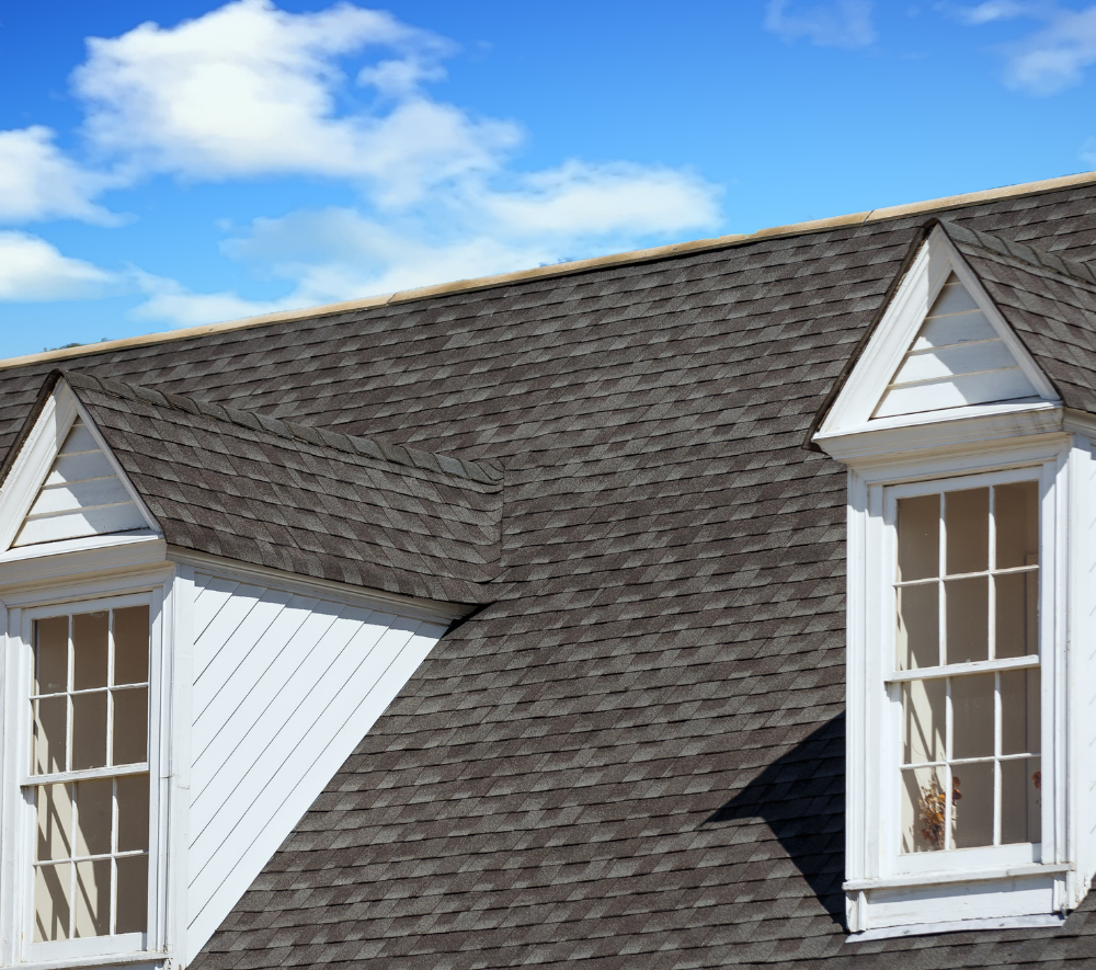 The roof of a house with two windows on it