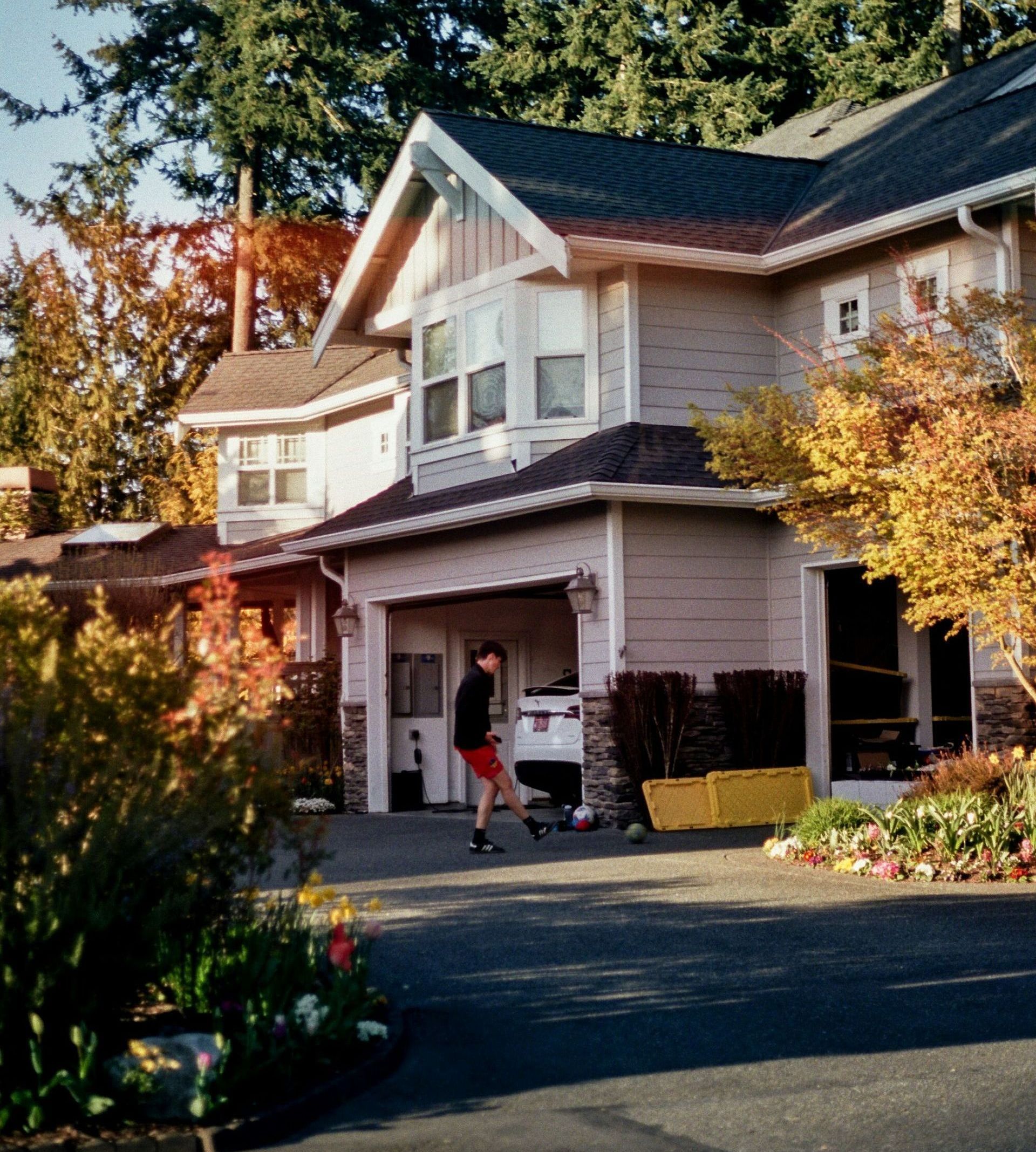 A man is standing in front of a large house