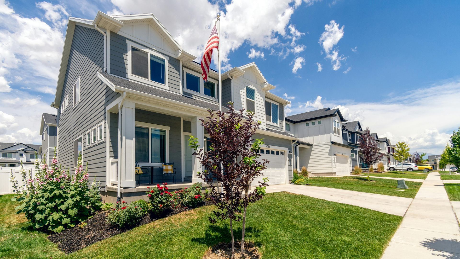 A house with an american flag flying in front of it in a residential neighborhood.