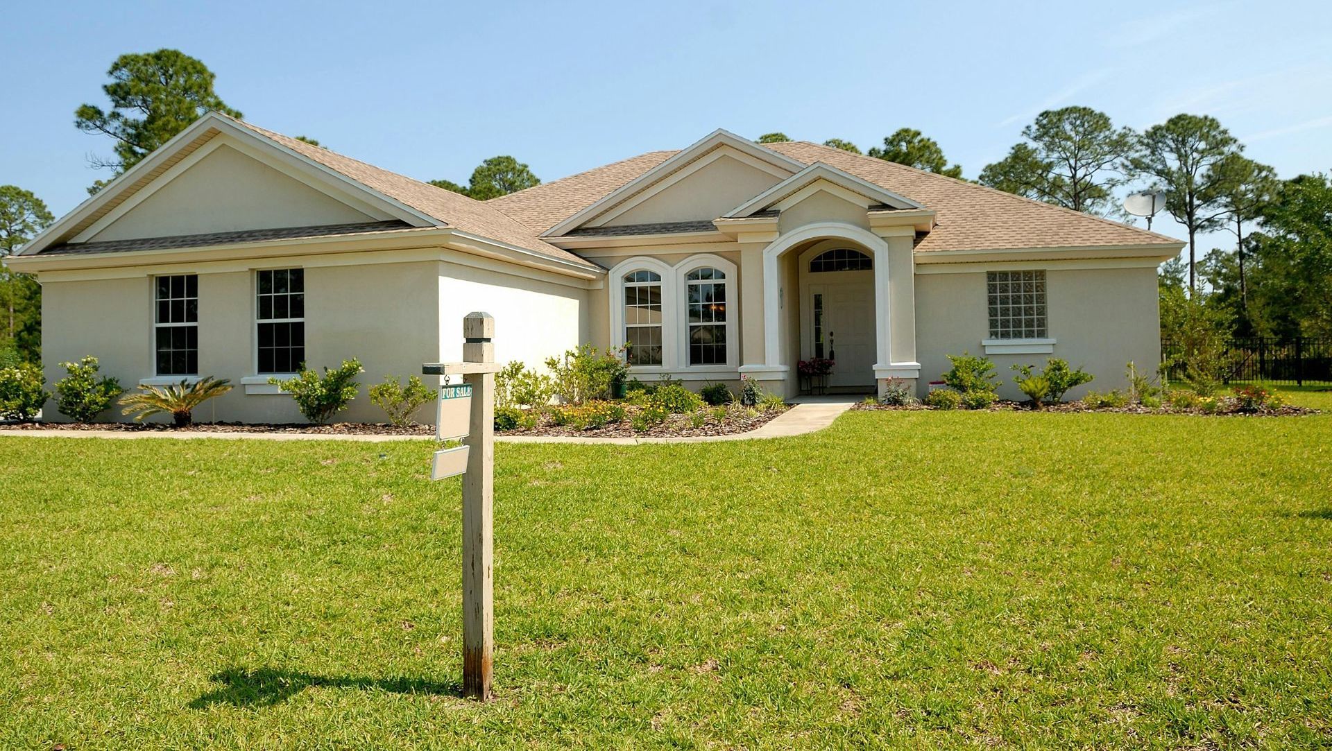 A house with a for sale sign in front of it