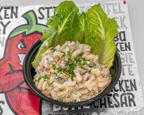 salad in a black bowl, garnished with lettuce on a textured background with text.