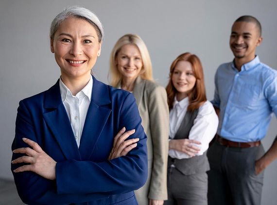 A group of business people standing next to each other with their arms crossed.
