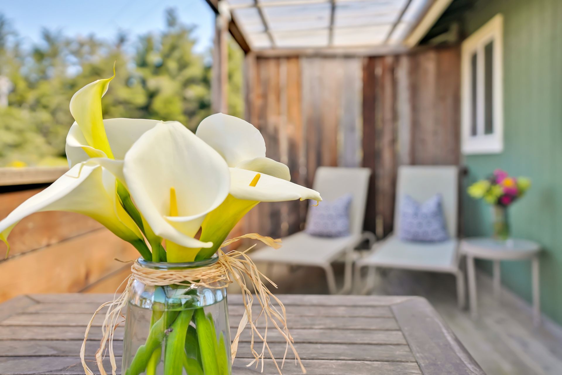 A vase of flowers is sitting on a wooden table.