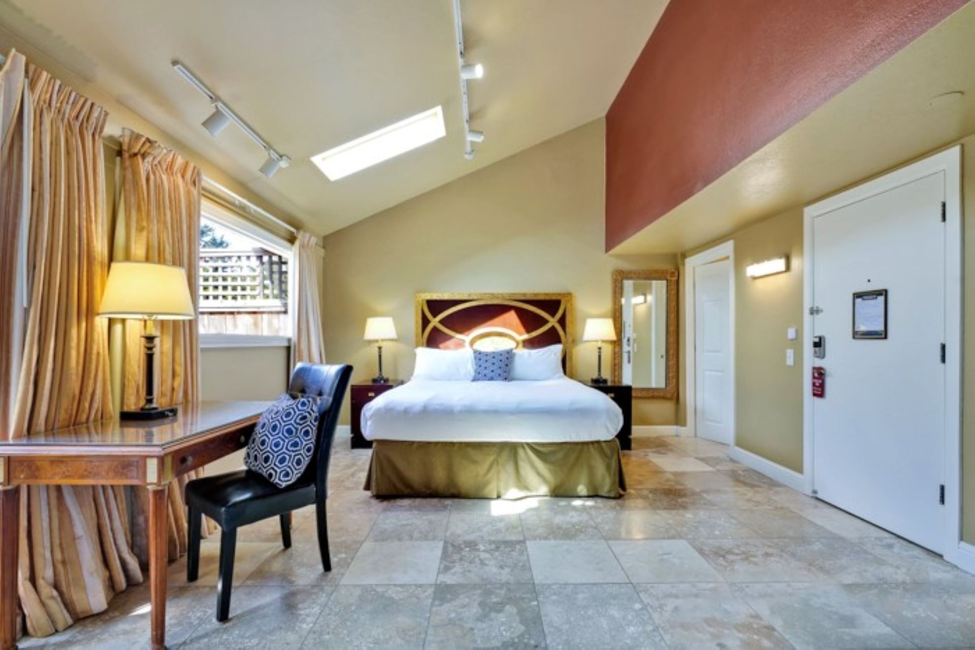 A hotel room with a large bed and a desk
