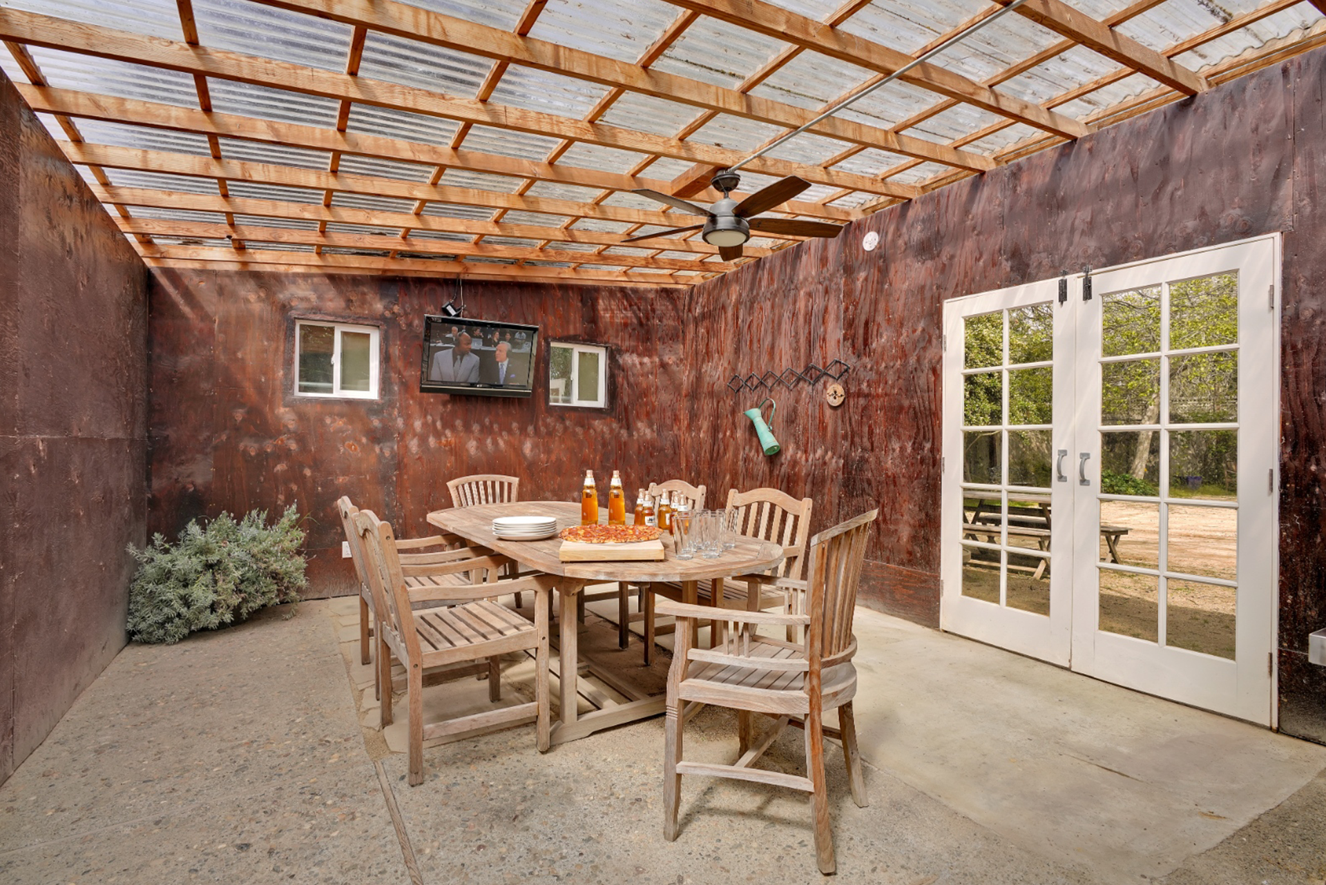 A patio with a table and chairs under a ceiling fan