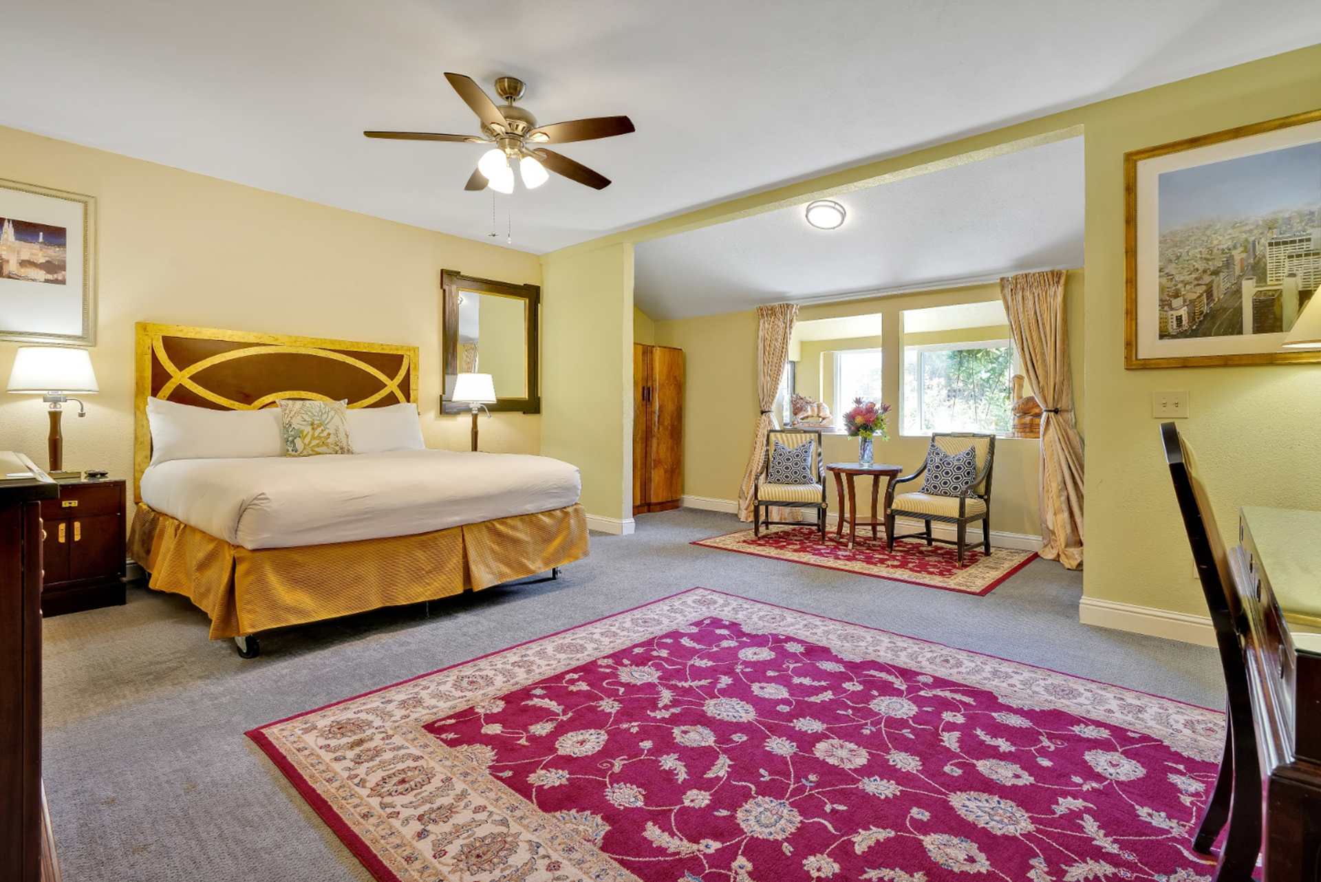 A hotel room with a king size bed and a purple rug.