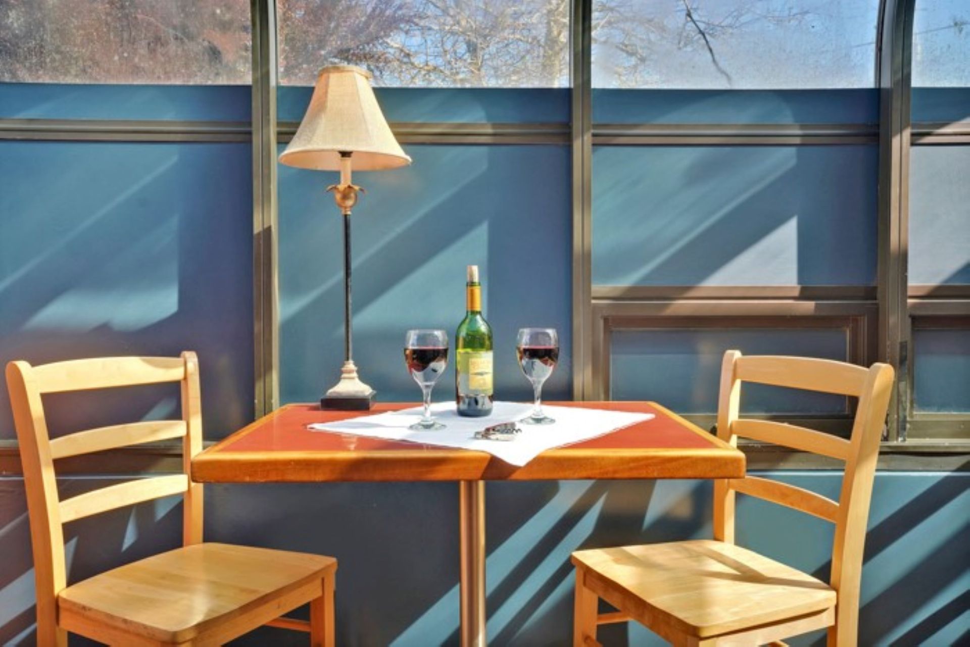 A table with a bottle of wine and two glasses on it