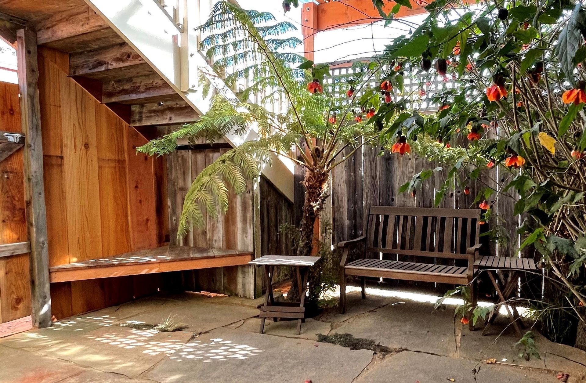 A wooden bench sits in the middle of a courtyard