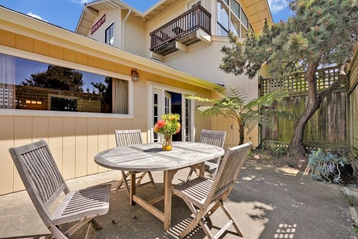 A patio with a table and chairs in front of a house.