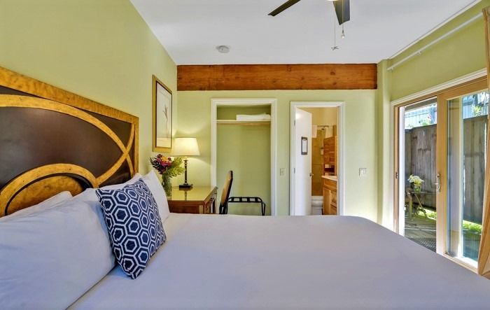 A bedroom with a king size bed and a ceiling fan.