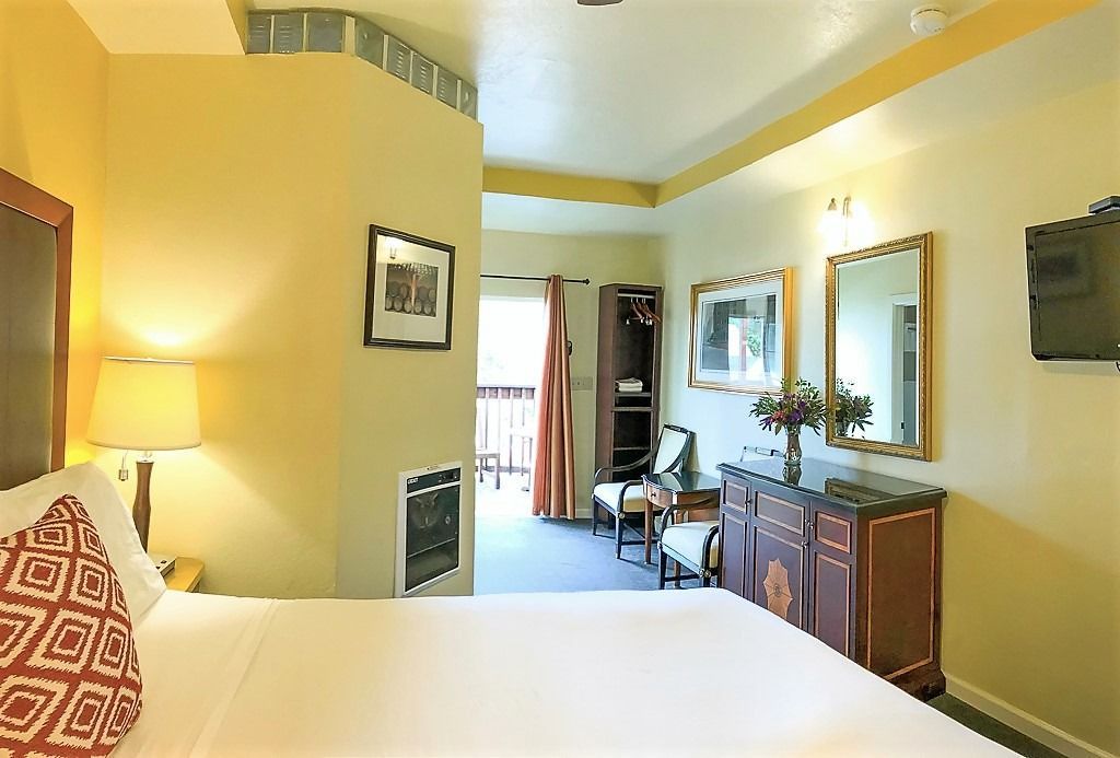 A hotel room with a large bed and a television