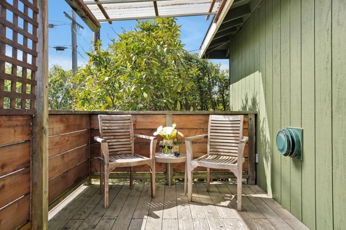 A wooden deck with two chairs and a table on it.