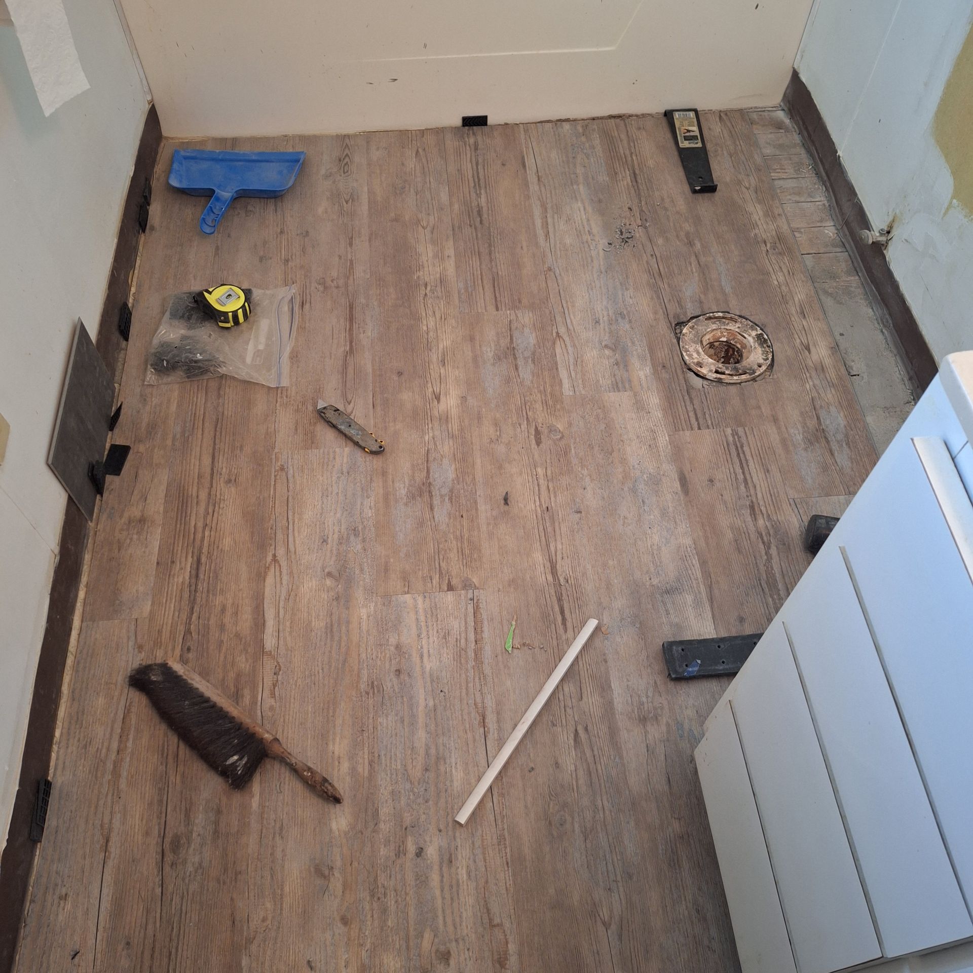 A wooden floor with tools on it in a bathroom