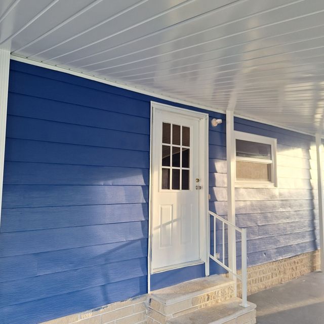 A blue house with a white door and stairs